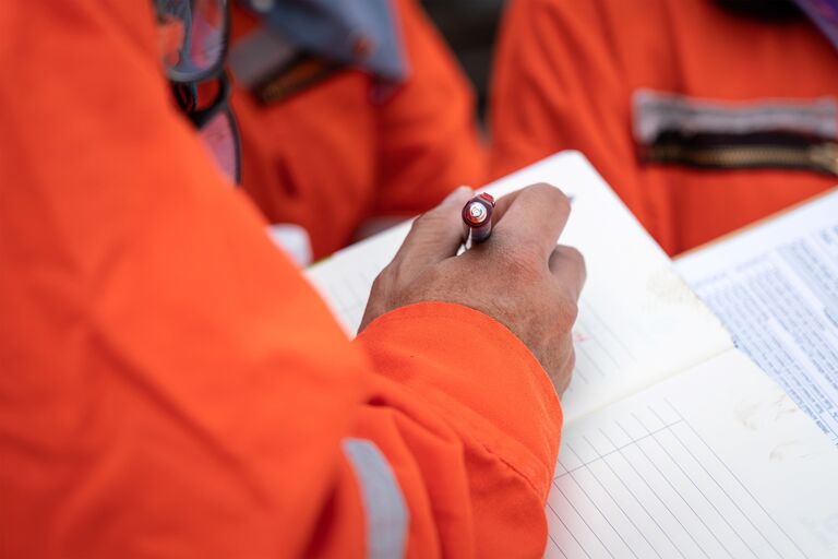 A worker writing down on a notebook