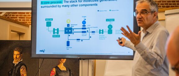 Jean Jouet presenting a slide with a title: "A core process: The stack for molecules generation, surrounded by many other components"