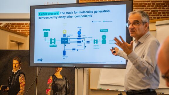 Jean Jouet presenting a slide with a title: "A core process: The stack for molecules generation, surrounded by many other components"